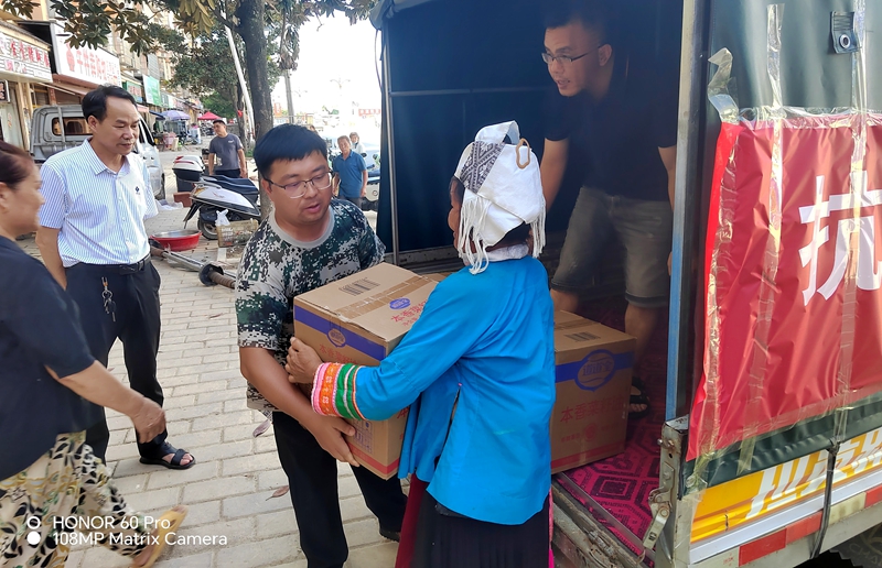 图为黎平县生态移民局和榕江县富民小区工作人员和群众一起搬运捐赠物资_proc.jpg